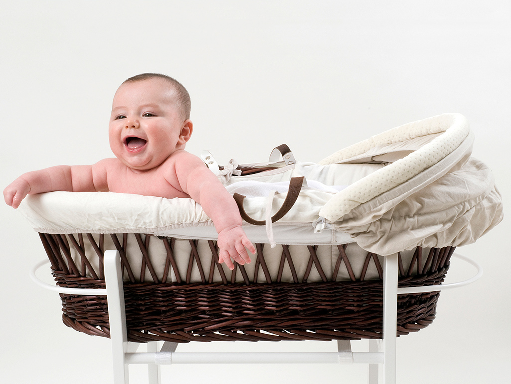 Baby laughing in moses basket