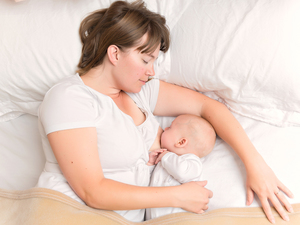 Mum breastfeeding her baby in bed