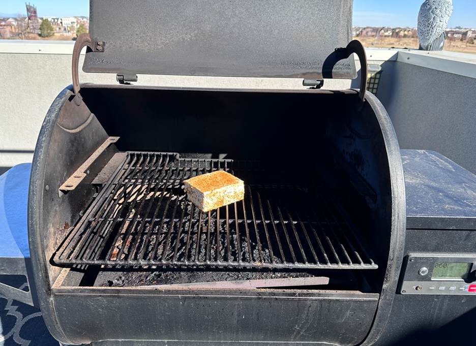 picture of the grill opened with a well-seasoned piece of tofu ready to be grilled.