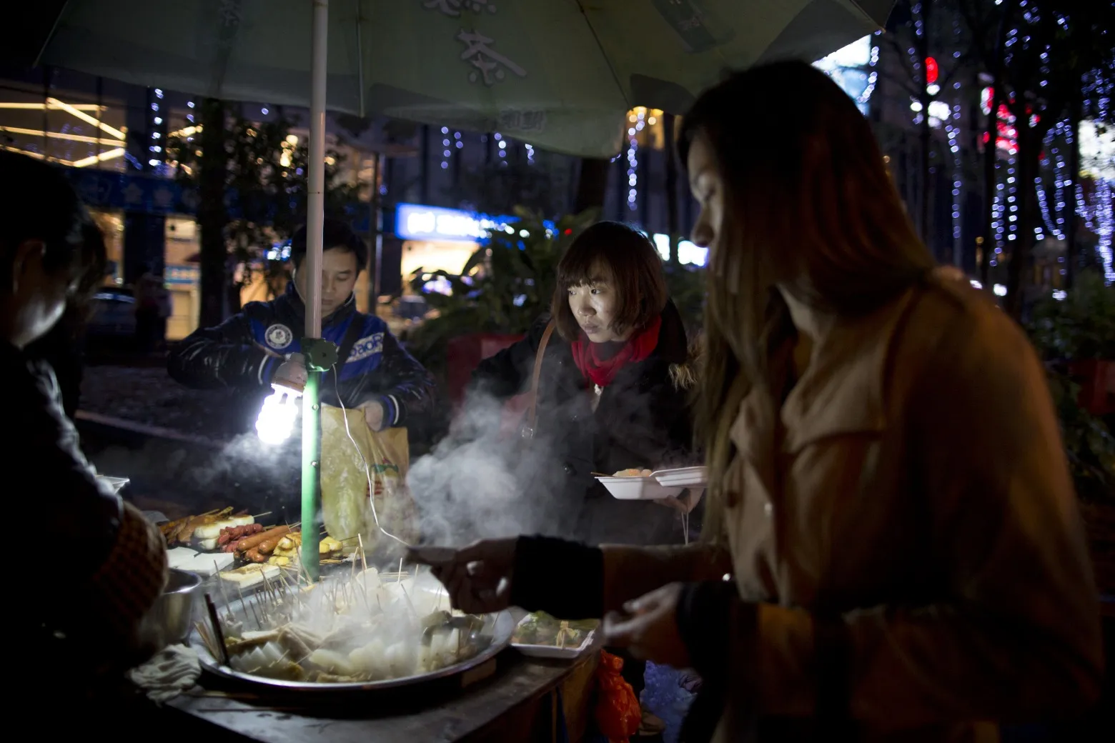 People purchase food from a roadside vendor in the Futian district of Shenzhen.