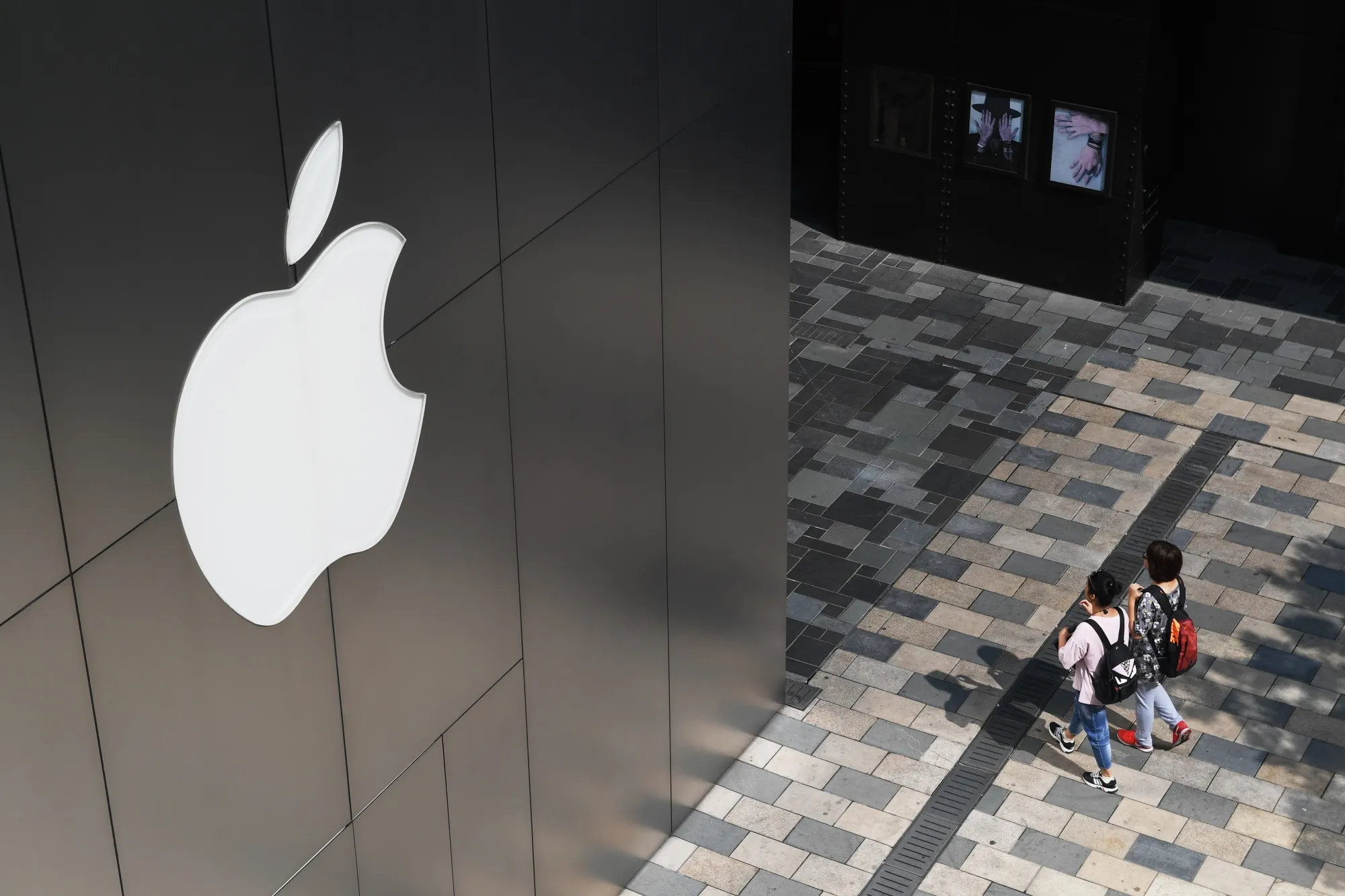 People walk past an Apple store in Beijing.