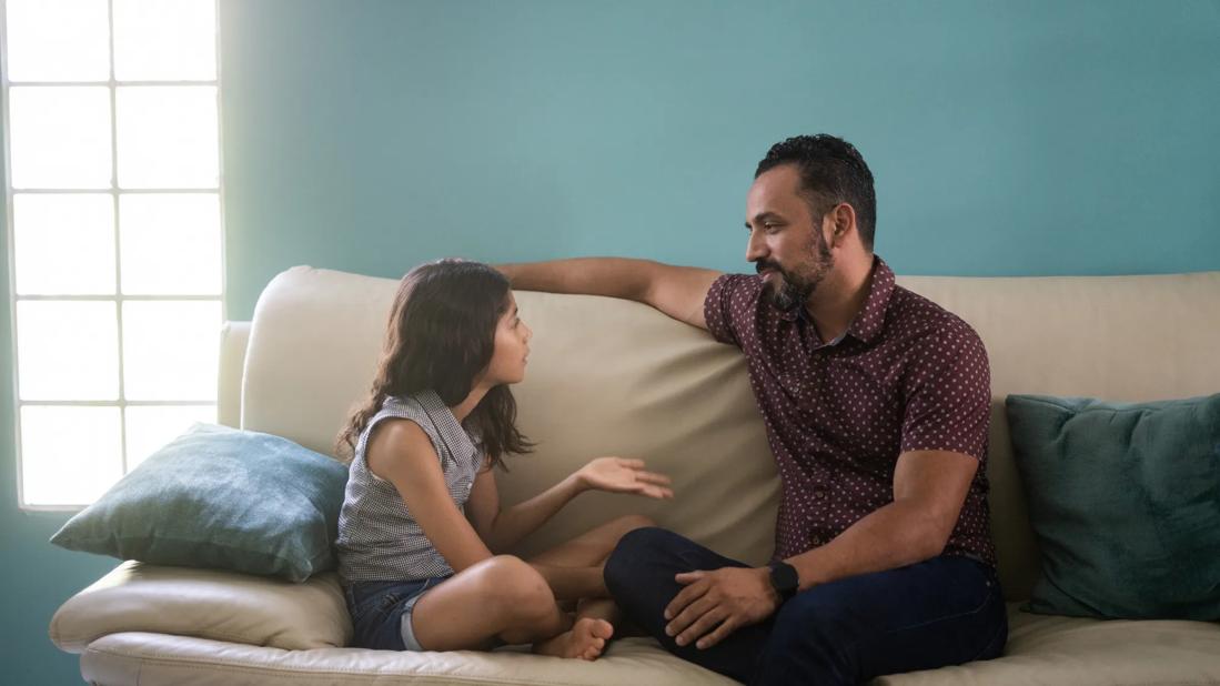 Child talking with caregiver on couch