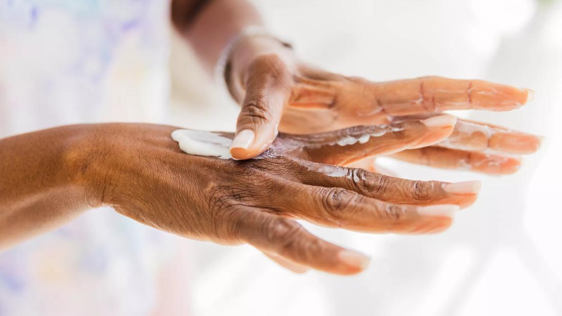 Moisturizer being applied to older hands