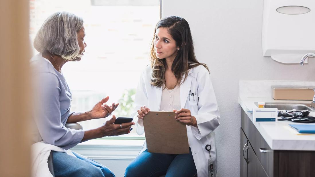 Healthcare provider and patient talking in exam room