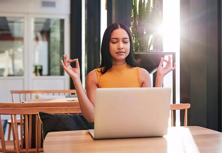 woman meditating at desk during break