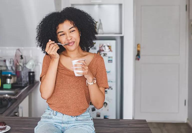 woman eating yogurt for breakfast