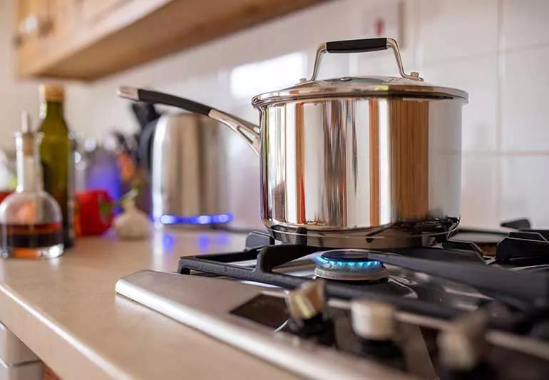 stovetop with stainless steel cookware and glassware