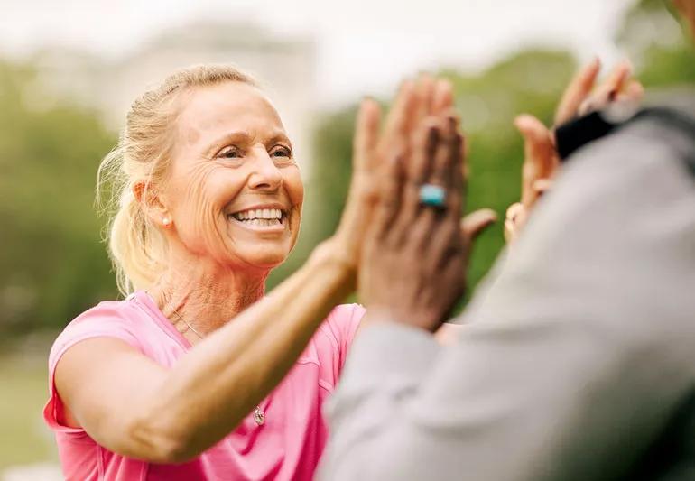 Happy older woman high-fiving her friend