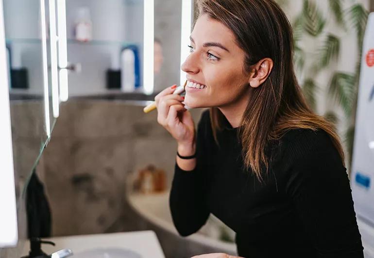 Person applying powder sunscreen with brush.