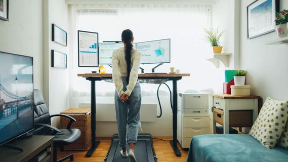 Person walking on walking pad at home office desk