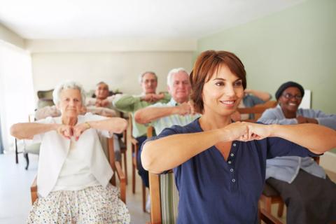 Seniors exercising with chairs