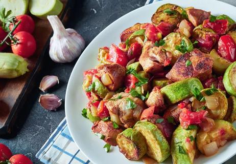 Plate of chicken ratatouille, with raw veggies on table