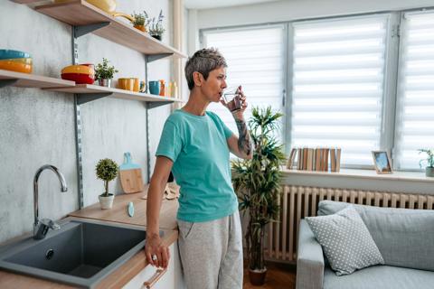 Person in kitchen drinking glass of water