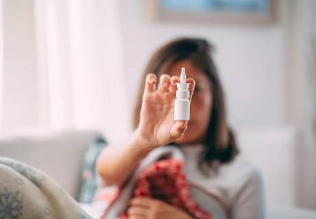 Person holding nasal spray.