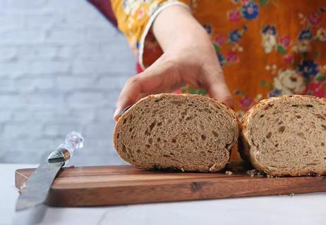 person with cut loaf of ezekiel bread