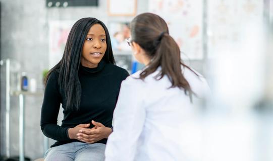 Person talking with healthcare provider in medical setting