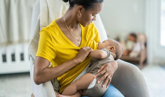 Female breastfeeding in baby's room