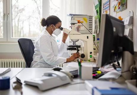 Scientist using microscope.