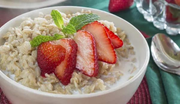Bowl of oatmeal with sliced strawberries on top