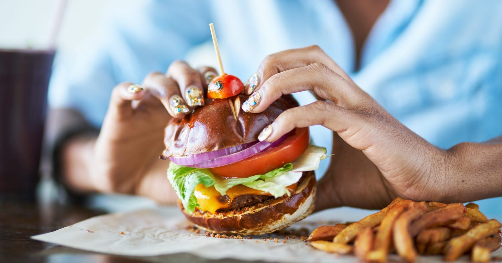 A woman going to pick up a vegan burger at a restaurant / Photo Credit: Joshua Resnick, Shutterstock