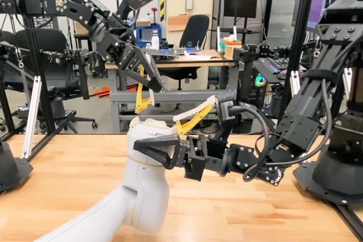 The Aloha Unleashed manipulator arms set up a robot repair shop, seen here autonomously replacing the gripper of another service robot