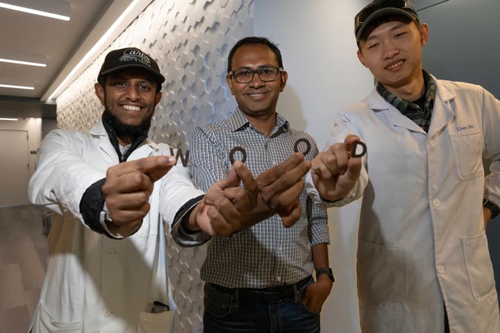 From left to right, team members M.S.H Thakur, Muhammad Rahman and Chen Shi pose with 3D-printed wooden letters produced as part of the study