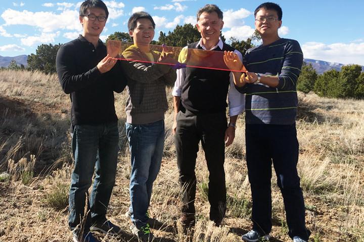 The researchers, (from left) Jaehoon Lim, Kaifeng Wu, Victor Klimov and Hongbo Li, holding a plane of their quantum dot LSC glass