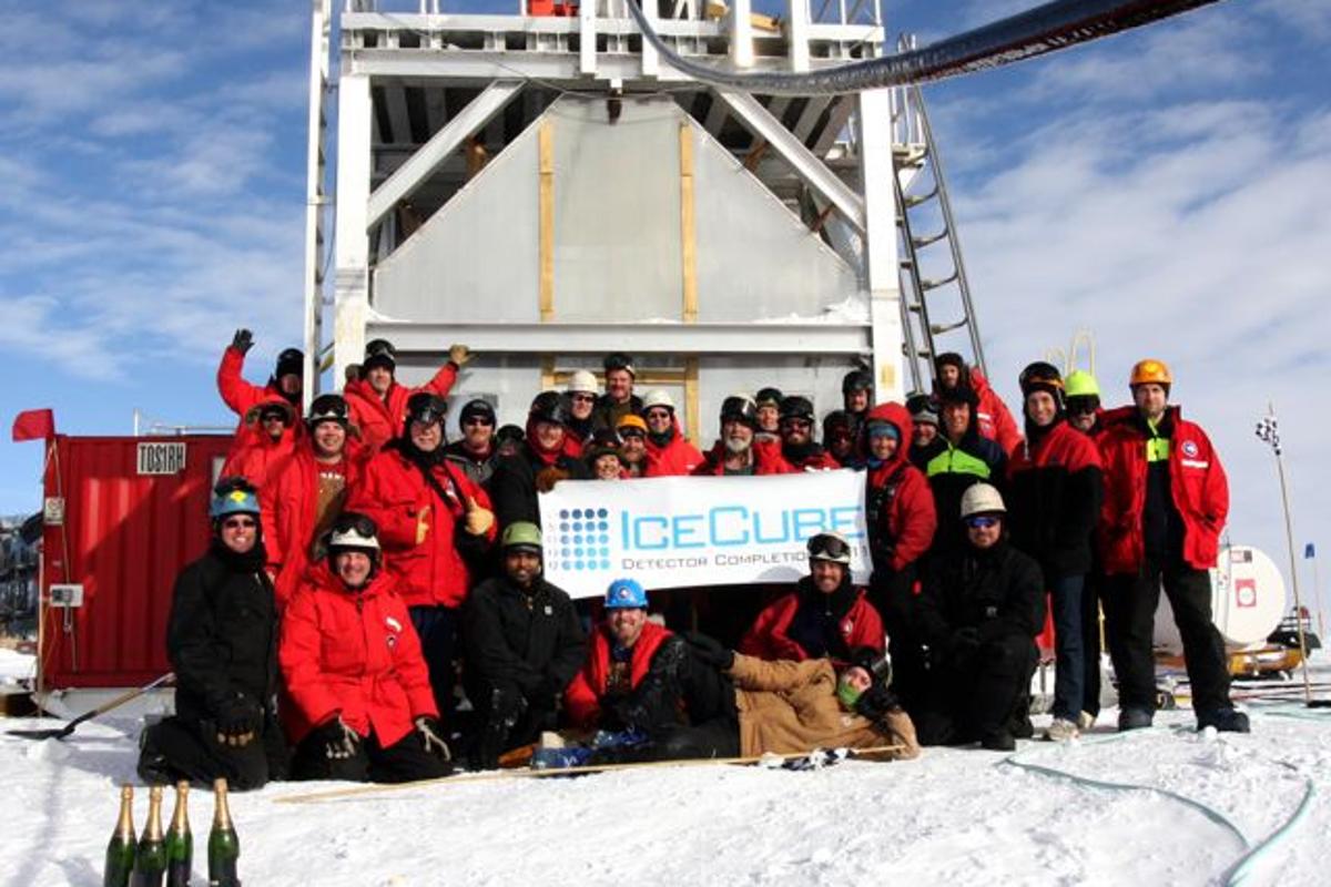 The IceCube team poses in front of the deployment tower following completion of the IceCube Neutrino Detector