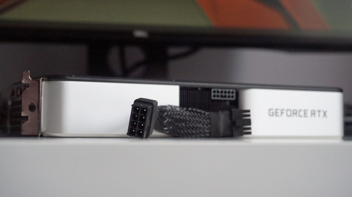 A photo  of the Nvidia GeForce RTX 3060 Ti Founders Edition and its 8-pin to 12-pin power connector adapter.