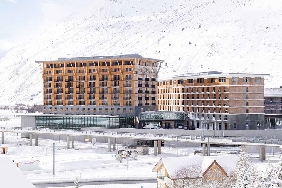 Moderne Gebäude in einer verschneiten Landschaft mit einer Brücke im Vordergrund