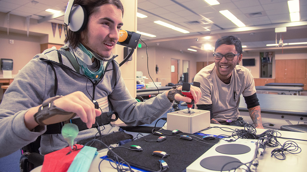 A man using Joysticks that are plugged into the Xbox Adaptive Controller