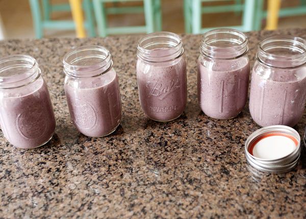 5 mason jars full of almond milk smoothies