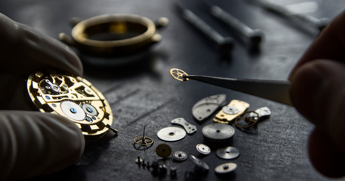 clock worker putting back together a watch