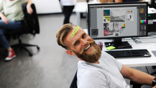 man with a tag on his forehead sitting in an office chair