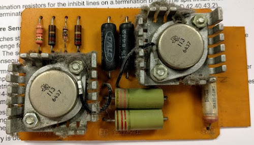 The IBM 1401 has four "AQW" cards that generate currents for the core memory switches. This card had a faulty inductor (the upper green cylinder), preventing core memory from working.