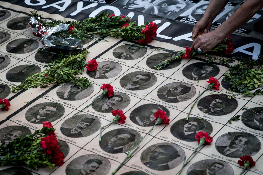 Personas dejando flores en el 103 aniversario del genocidio armenio.