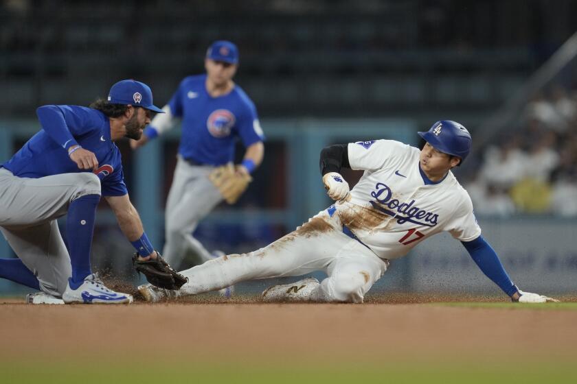 El japonés Shohei Ohtani, bateador designado de los Dodgers de Los Ángeles, se roba la intermedia ante Dansby Swanson, de los Cachorros de Chicago, el miércoles 11 de septiembre de 2024 (AP Foto/Ashley Landis)