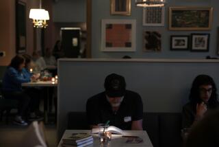 SILVER LAKE, CALIFORNIA April 23, 2024-Tim Cummings reads during a Silver Lake Reading Club meeting at the LAMILL coffee house. The group meets every Tuesday night for two hours. (Wally Skalij/Los Angeles Times)