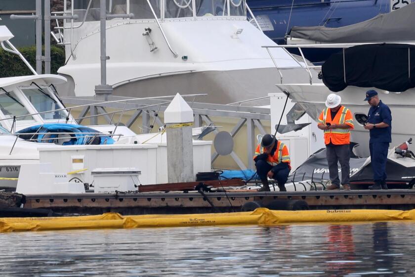 MARINA DEL REY, CA - SEPTEMBER 19, 2024 - An investigation is underway at the scene where a luxury yacht went down in flames Wednesday night when fireworks aboard the boat exploded in Marina del Rey on Thursday, September 19, 2024. The fully submerged yacht was surrounded by a boom to collect any oil leaking from the vessel. (Genaro Molina/Los Angeles Times)