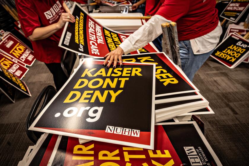 Glendale, CA - October 16: Members of the National Union of Healthcare Workers make signs at a Glendale union office for a potential strike on Wednesday, Oct. 16, 2024 in Glendale, CA. (Jason Armond / Los Angeles Times)