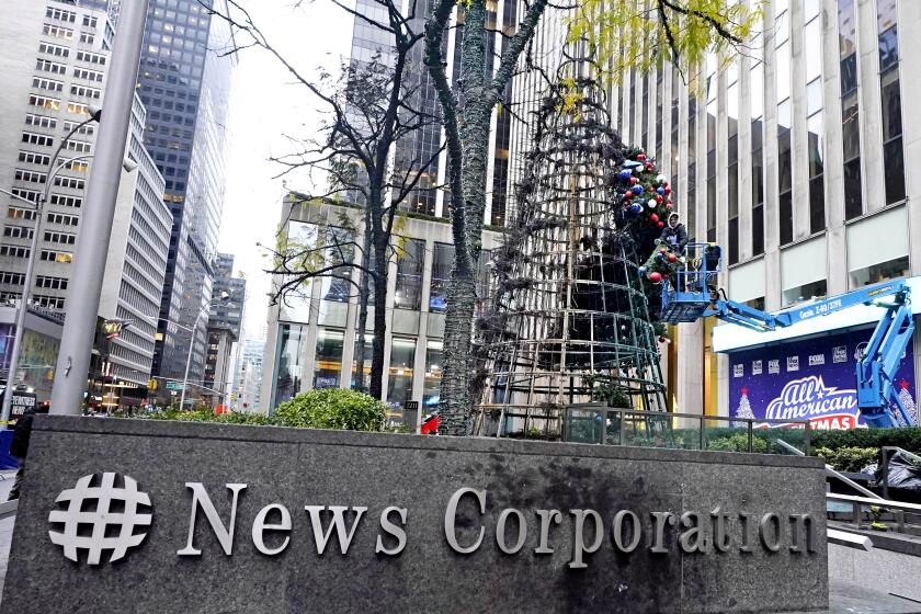 A worker disassembles a Christmas tree outside Fox News headquarters, in New York, Wednesday, Dec. 8, 2021. Police say a man is facing charges including arson for setting fire to a 50-foot Christmas tree in front of Fox News headquarters in midtown Manhattan. The tree outside of the News Corp. building that houses Fox News, The Wall Street Journal and the New York Post caught fire early Wednesday. (AP Photo/Richard Drew)