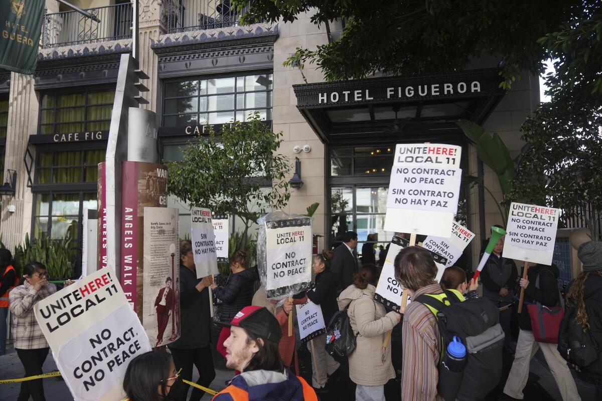 Workers hold picket signs outside Hotel Figueroa