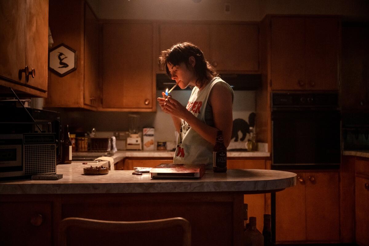 A woman stands in her kitchen.