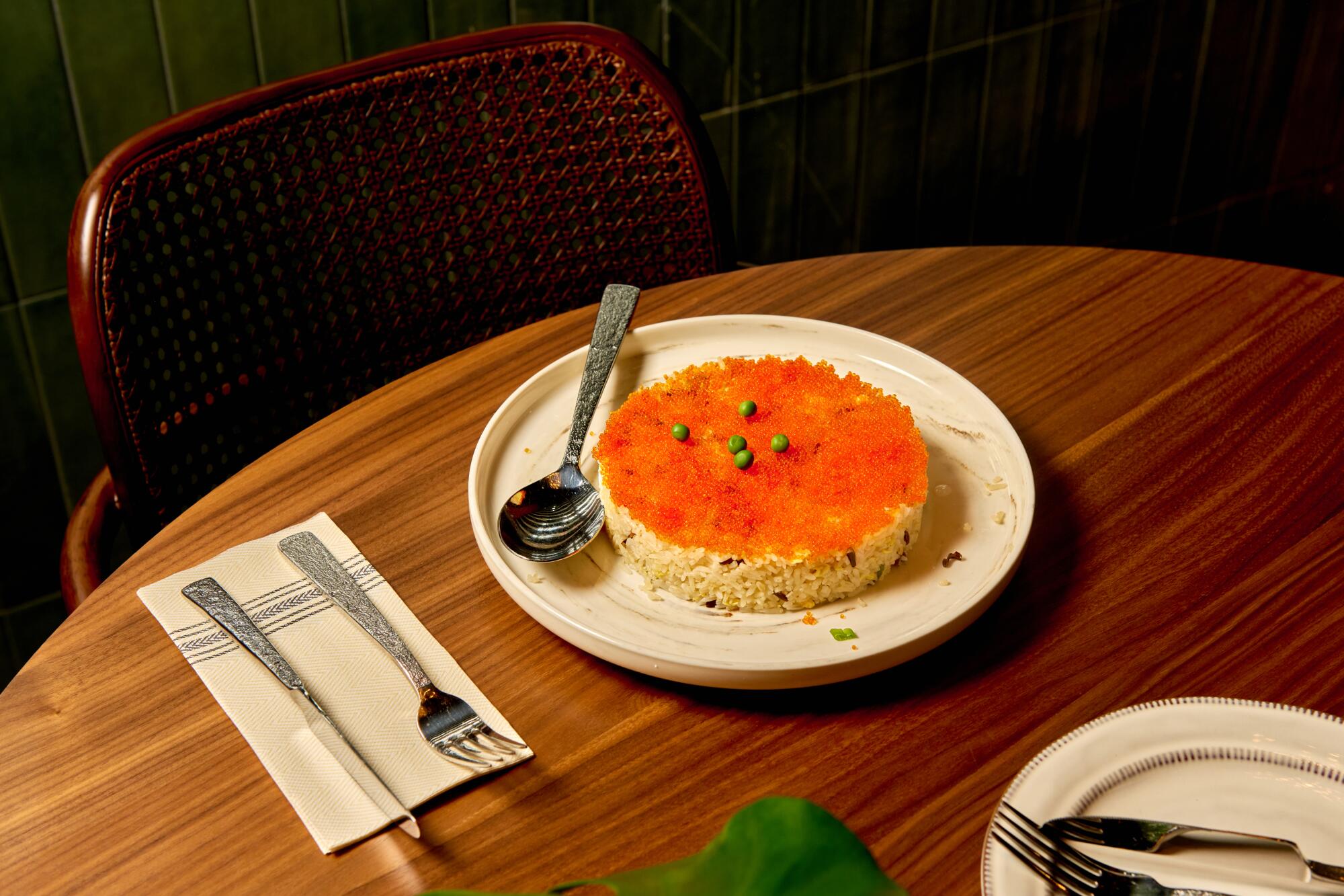 Royal Crown fried rice with white and black jasmine rice shaped in a circular mold topped with fish roe.