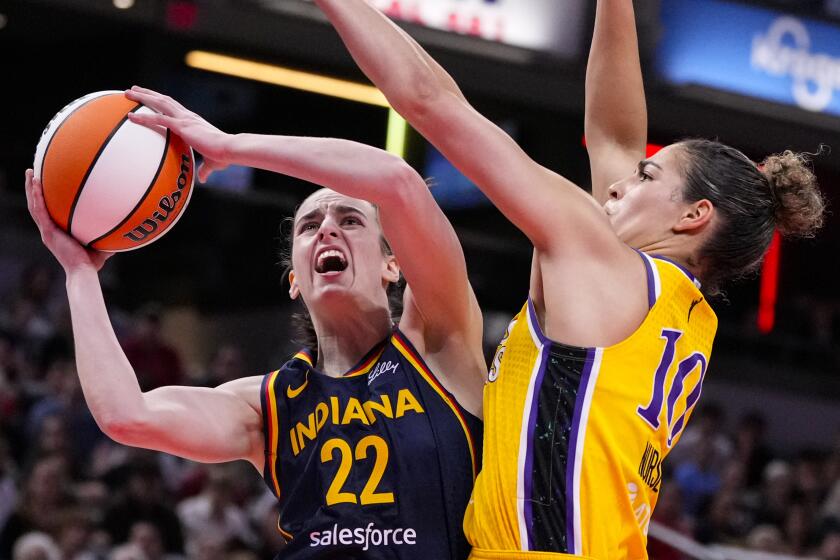 Indiana Fever guard Caitlin Clark (22) shoots around Los Angeles Sparks guard Kia Nurse