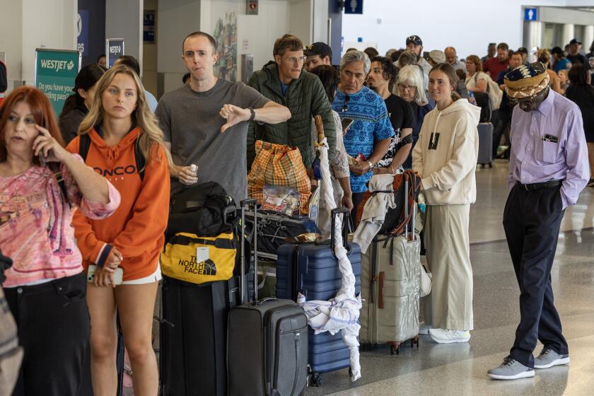 LOS ANGELES, CA - JULY 19: A passenger in the Delta re-booking line shows his displeasure with the experience on Friday, July 19, 2024. LAX was affected by a global technology outage. (Myung J. Chun / Los Angeles Times)