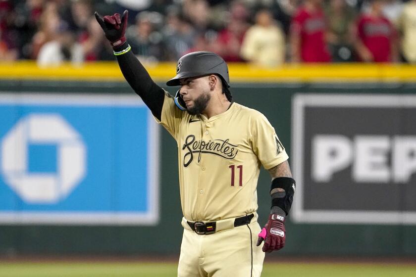 El venezolano José Herrera, de los Diamondbacks de Arizona, festeja luego de pegar un doble de terreno para producir una carrera frente a los Rangers de Texas, el martes 10 de septiembre de 2024 (AP Foto/Darryl Webb)