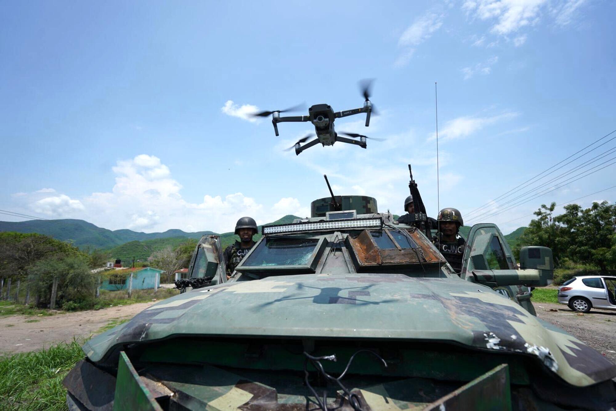 A drone flies above a vehicle.