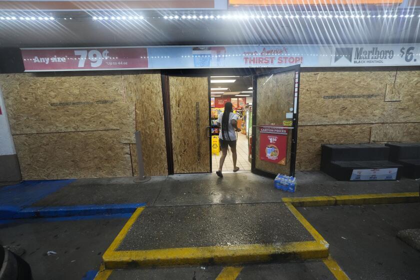 A customer enters a gas station that is boarded up in anticipation of Hurricane Francine, in Morgan City, La., Wednesday, Sept. 11, 2024. (AP Photo/Gerald Herbert)