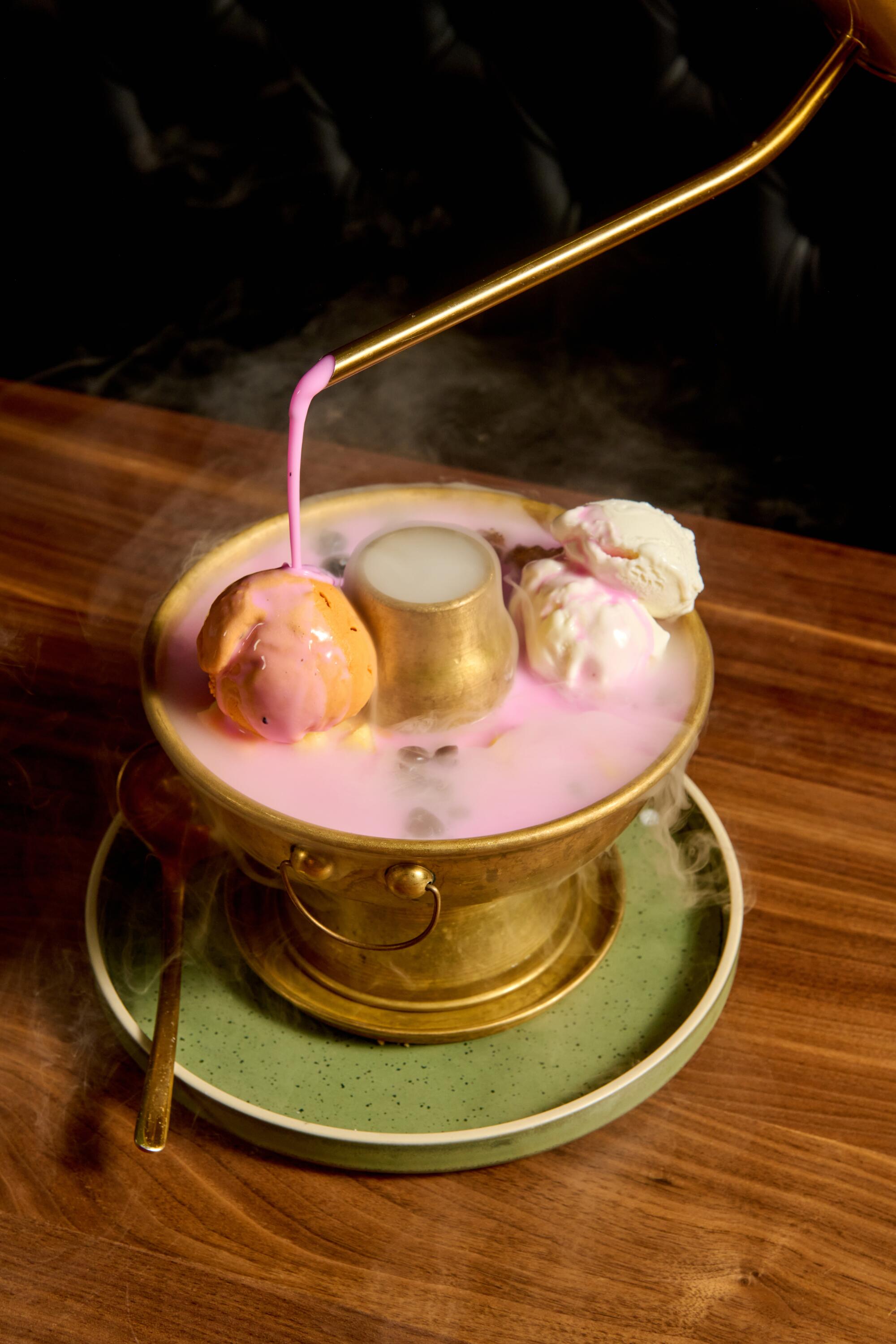 A server pours pink coconut cream over the Pink Mekong dessert.